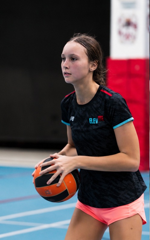 Elevate player holding a netball on court