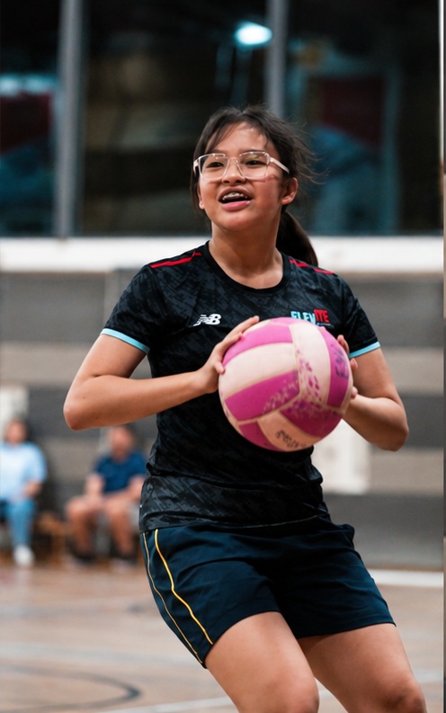 Elevate player holding a pink netball during training
