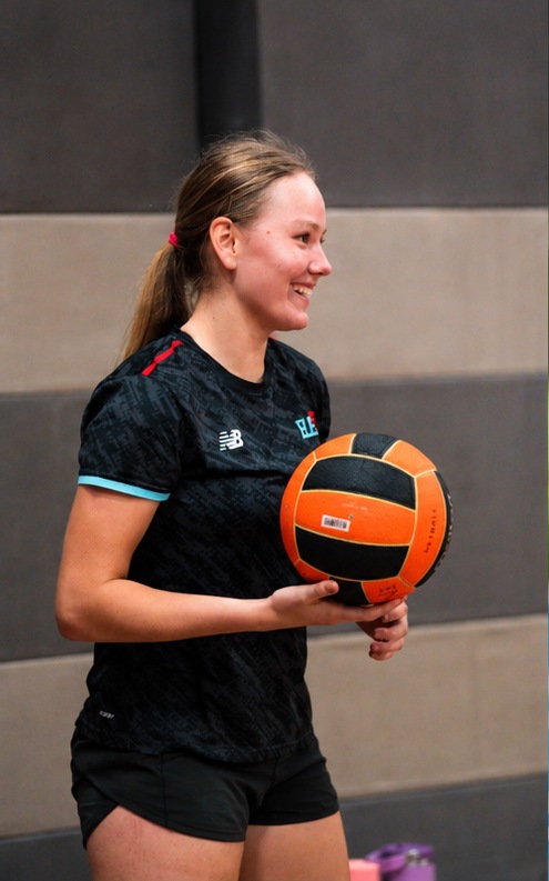 Elevate player holding an orange netball